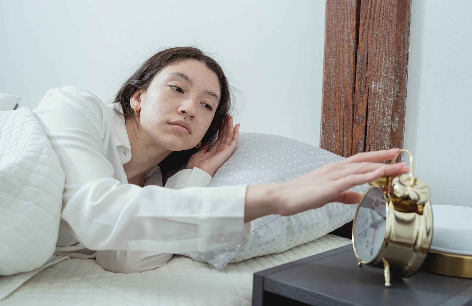 young woman waking up with alarm clock
