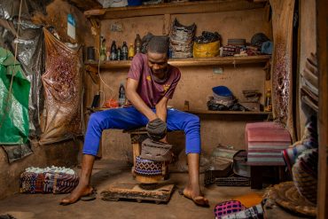 young artisan crafting traditional shoes in kano nigeria