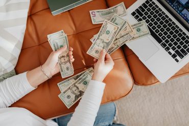 close up of woman counting dollar bills