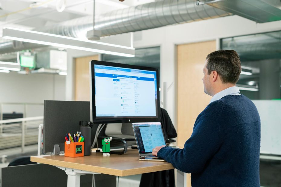 a man in blue long sleeves using a laptop