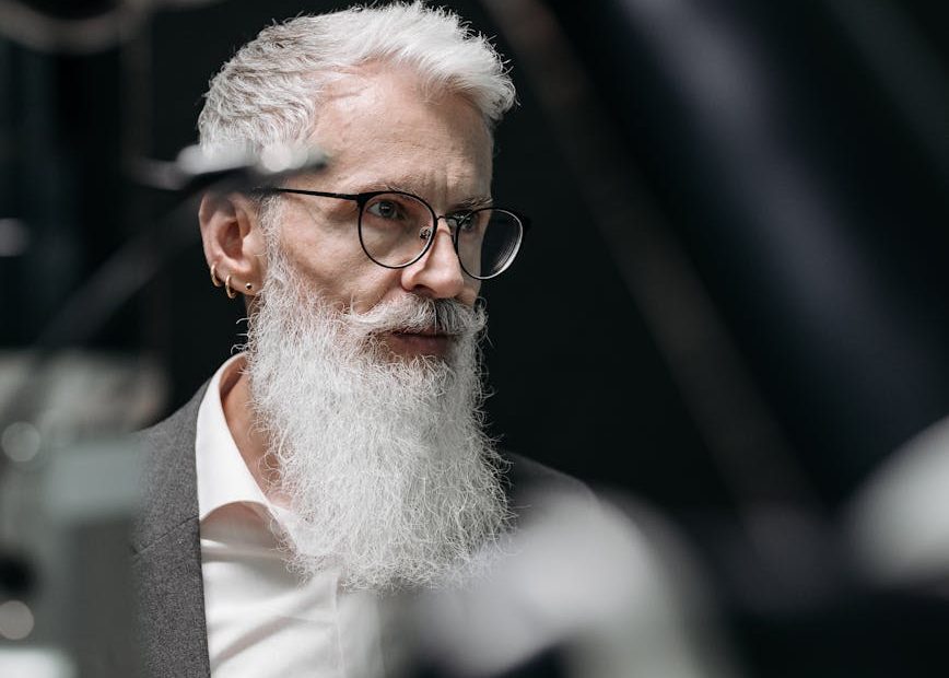 man with white hair and beard wearing eyeglasses